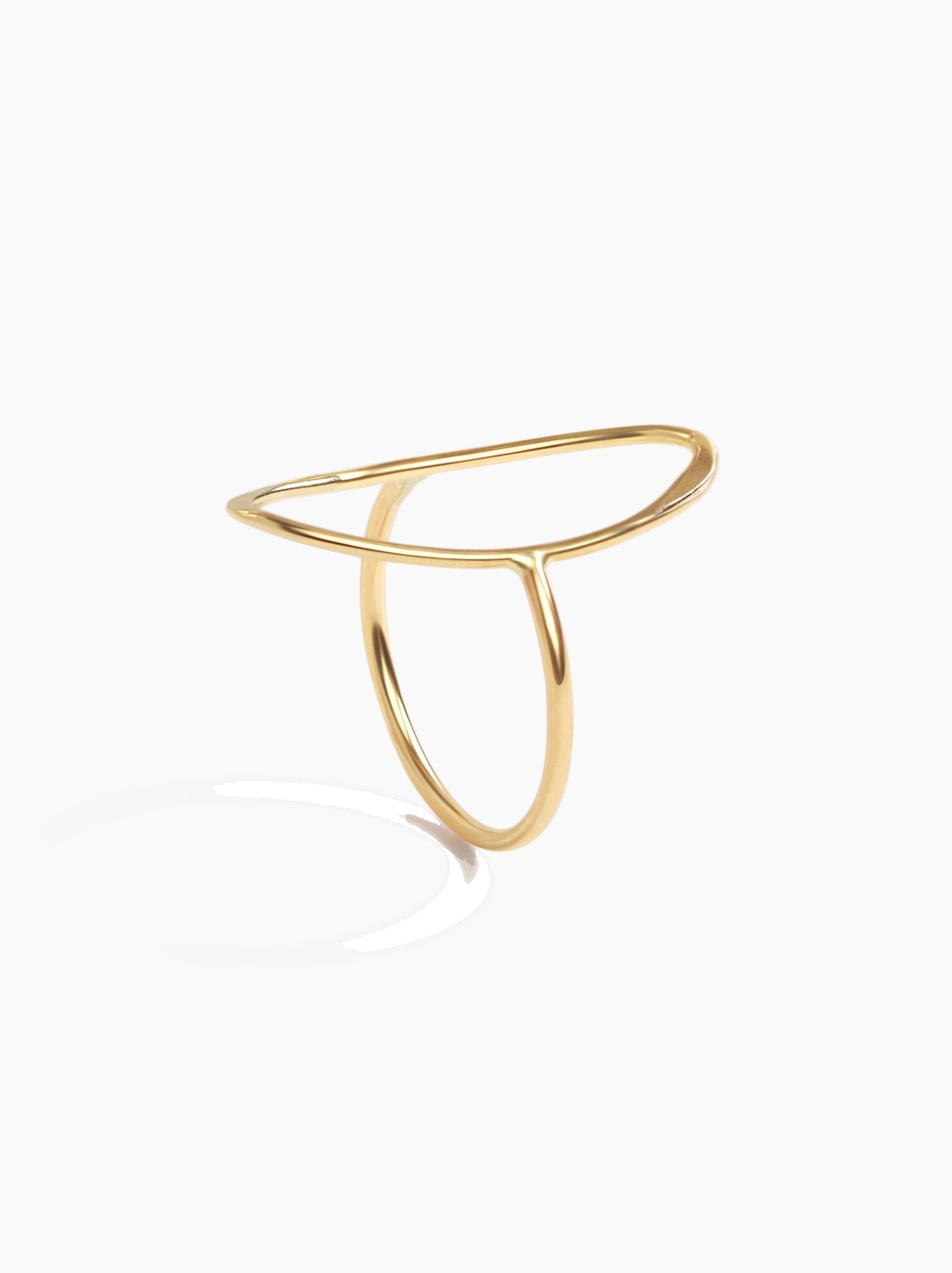 Gold oval ring standing up on band on a white background.