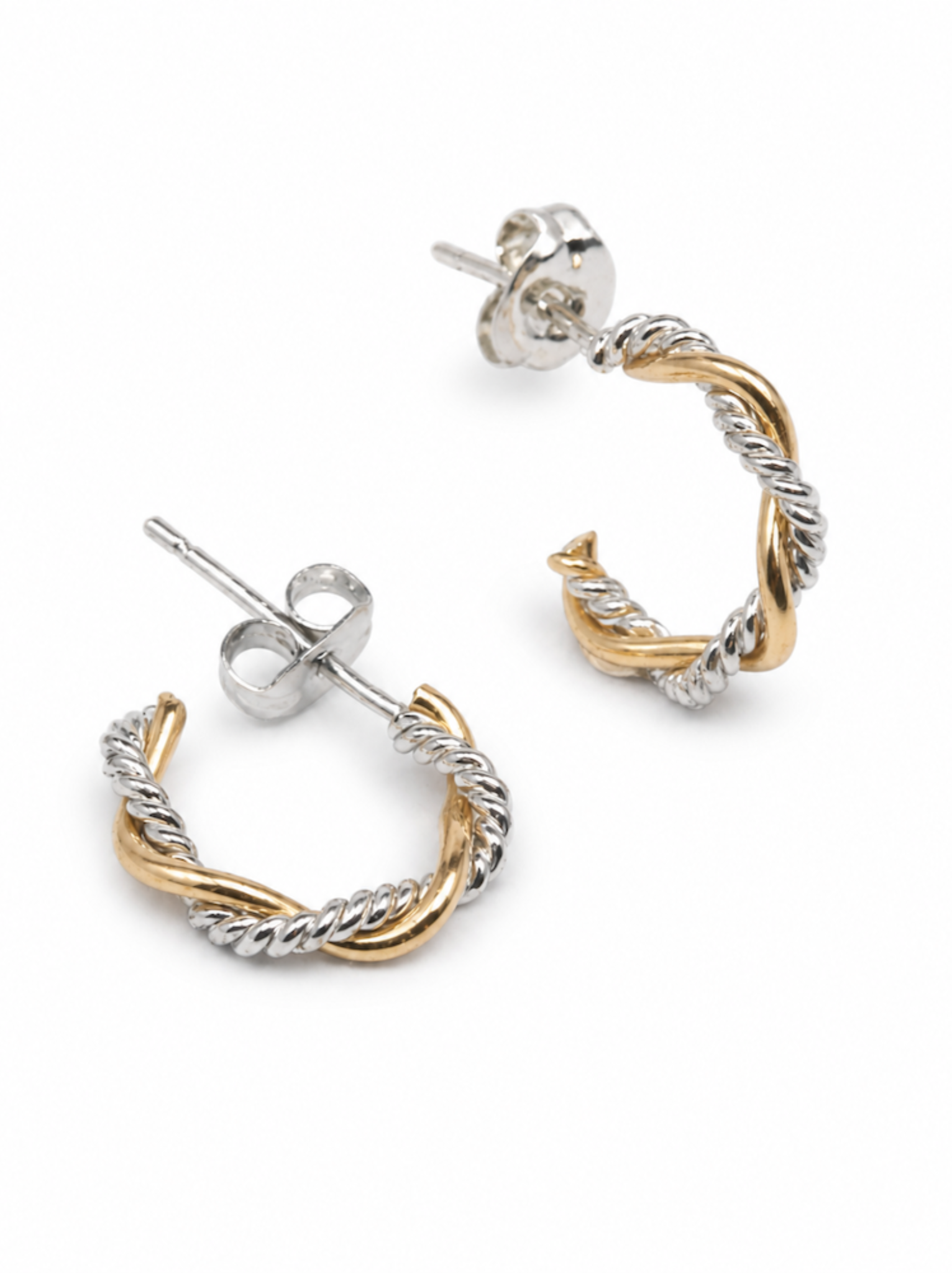 Pair of mini braided hoop earrings with a smooth gold and textured silver finish with ear posts on a white background.