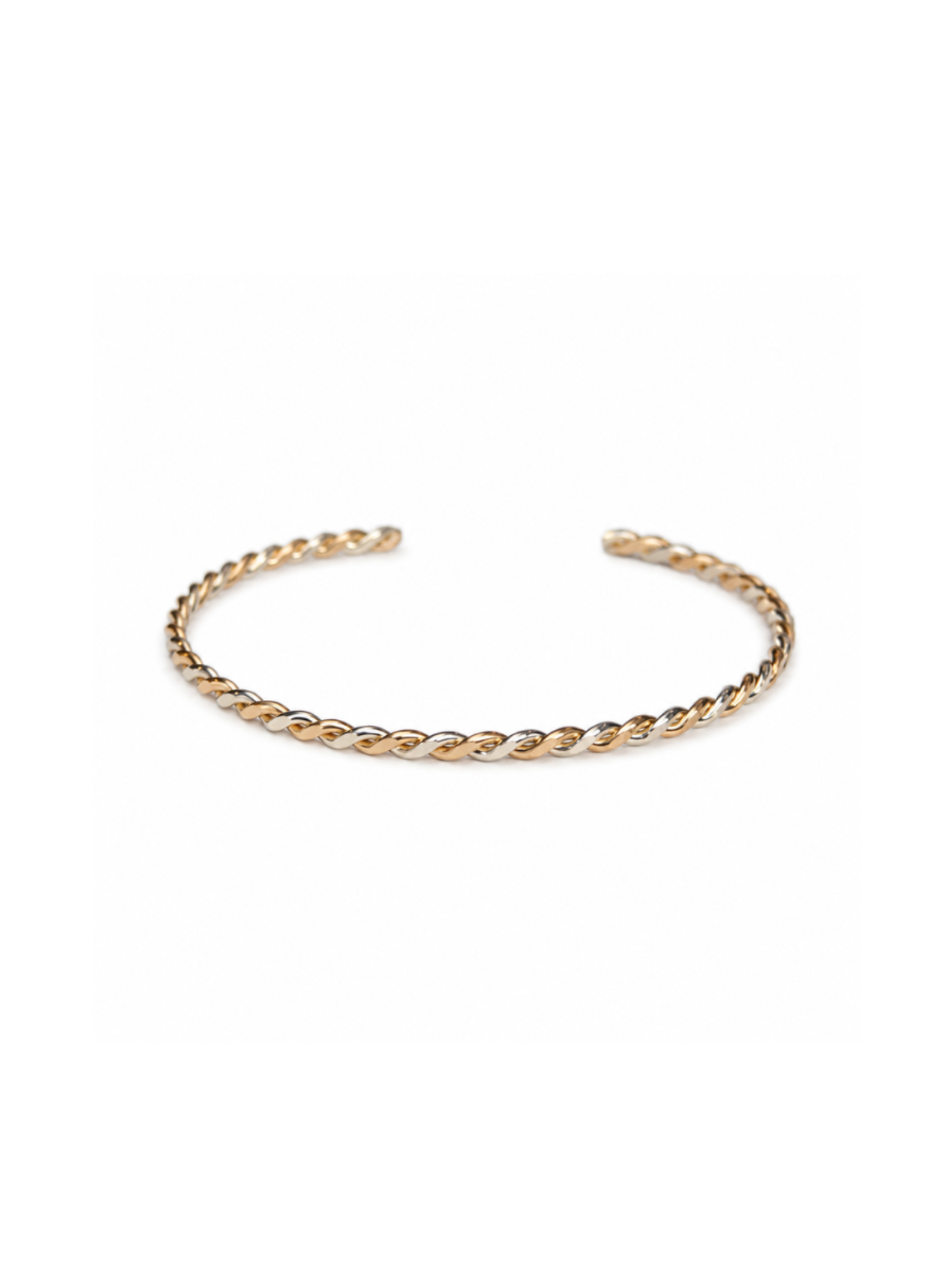 Bird's eye view of braided gold and silver cuff bracelet on white background.