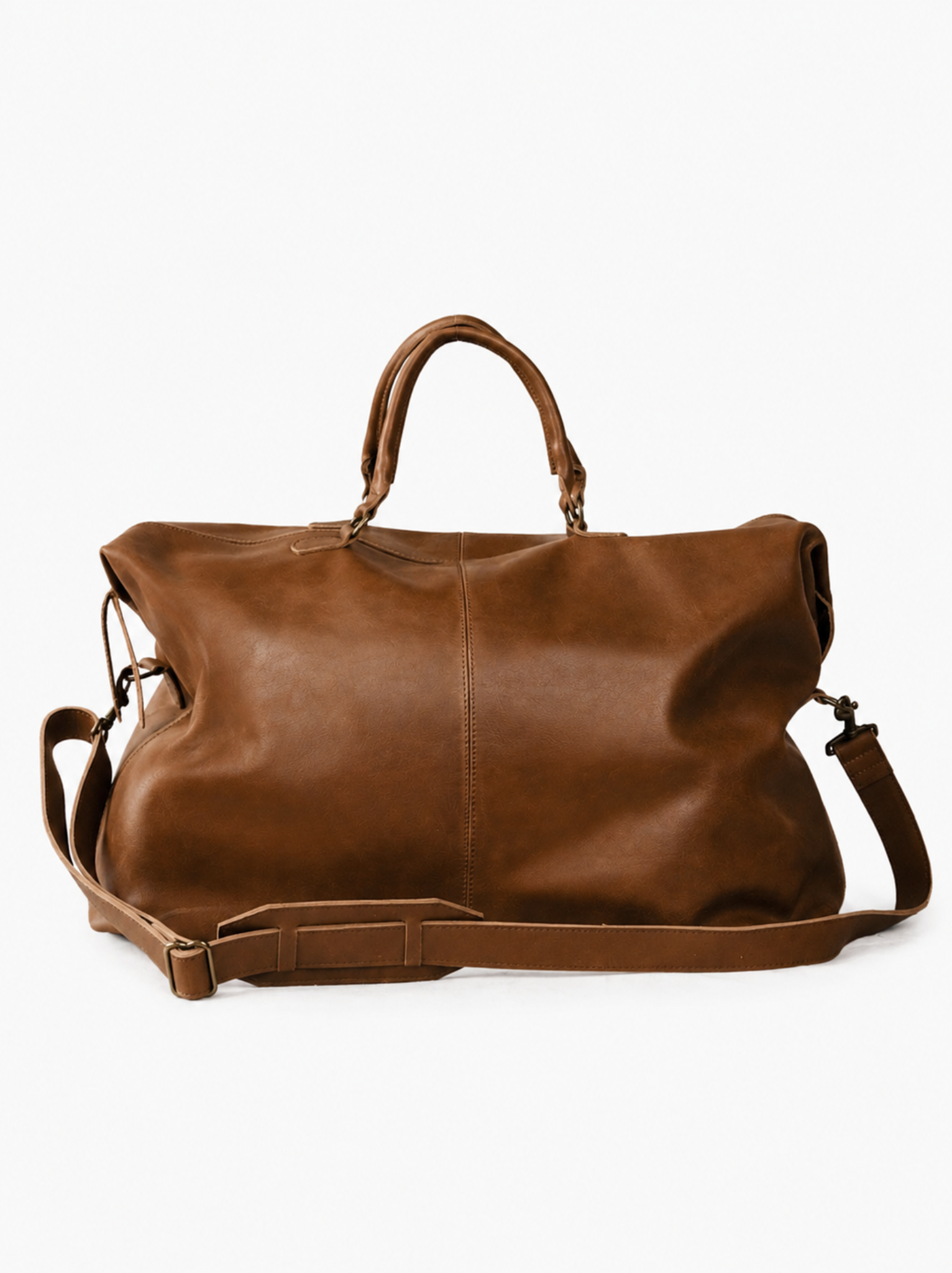 A brown leather duffel bag with dual top handles and a detachable, adjustable shoulder strap, photographed against a clean white background. #Color_Whiskey