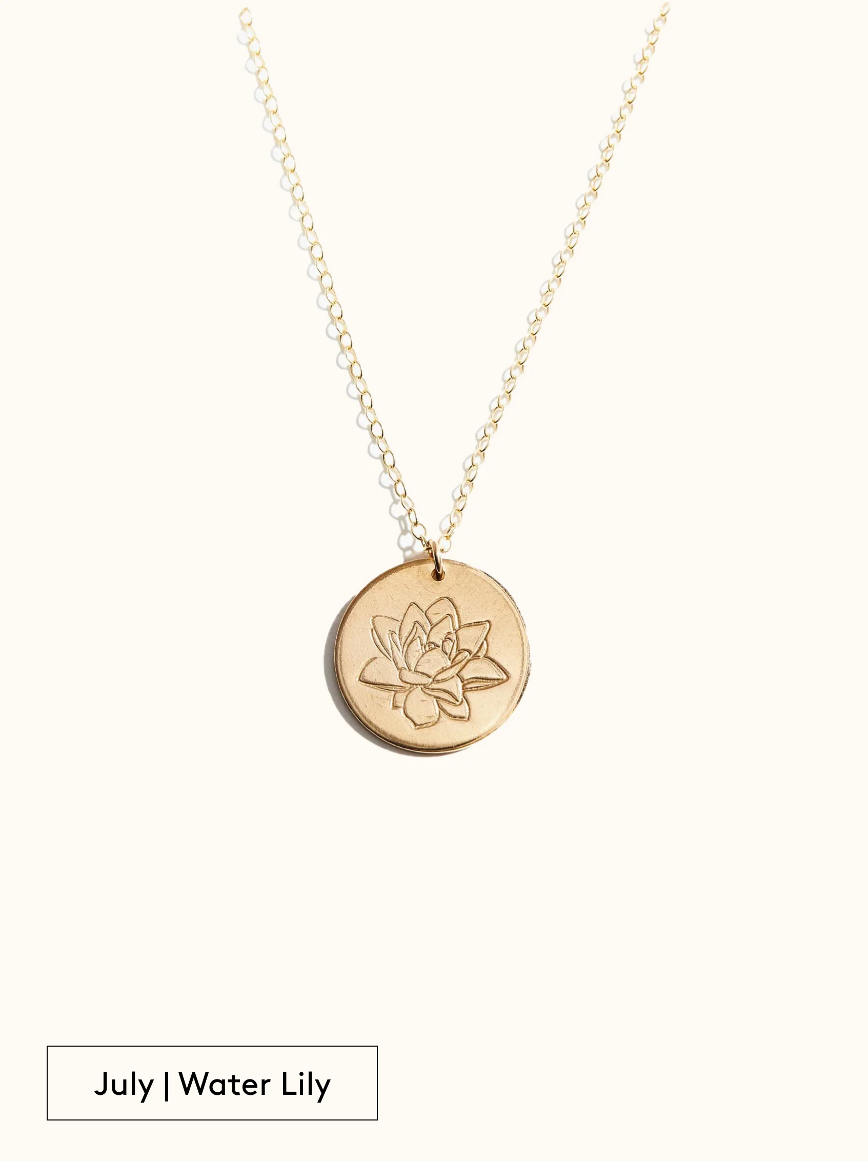 A gold-filled necklace with a round tag pendant featuring an engraved Water Lily, noted as July's birth month flower, attached to a 24 inch chain on a neutral background.