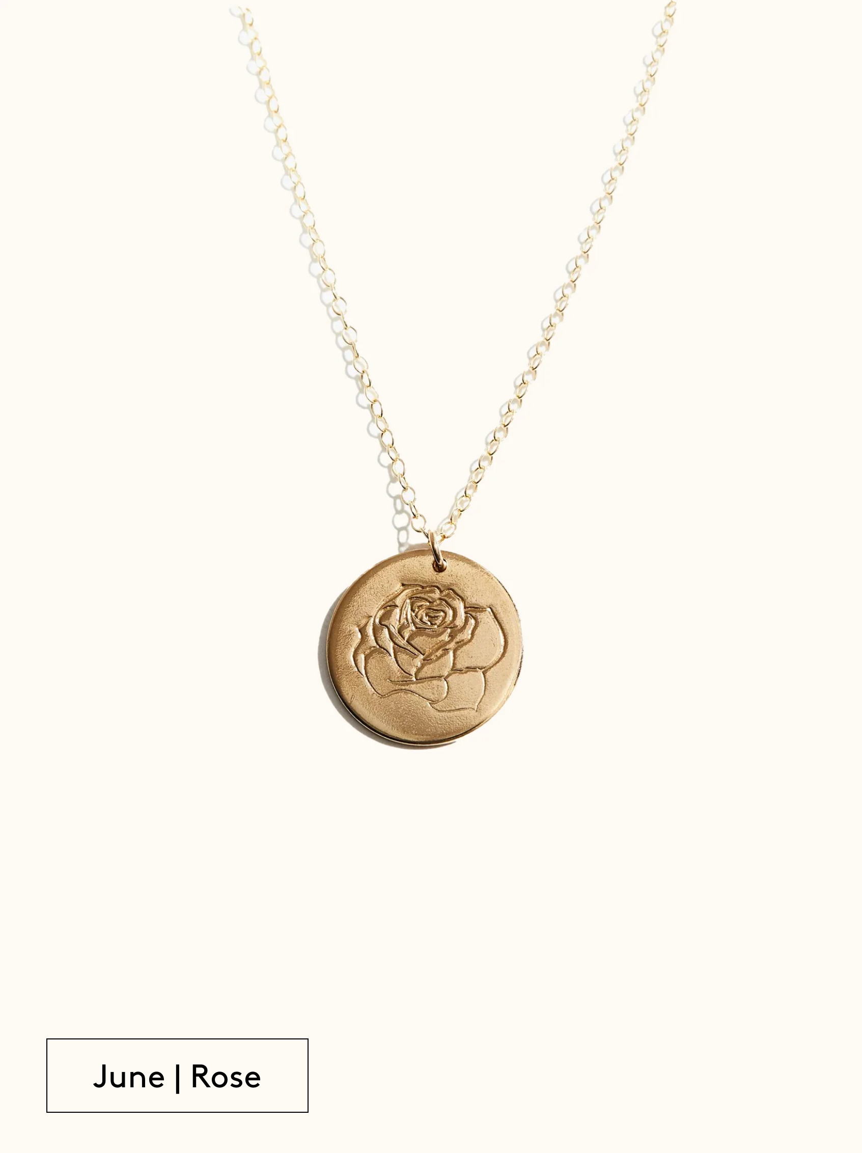A gold-filled necklace with a round tag pendant featuring an engraved Rose, noted as June's birth month flower, attached to a 24 inch chain on a neutral background.