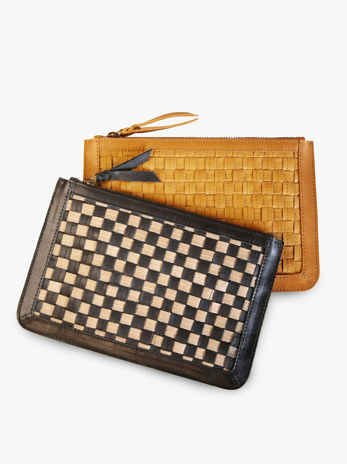 Black and tan clutch lying on top of brown clutch on a white background. #Color_Cognac