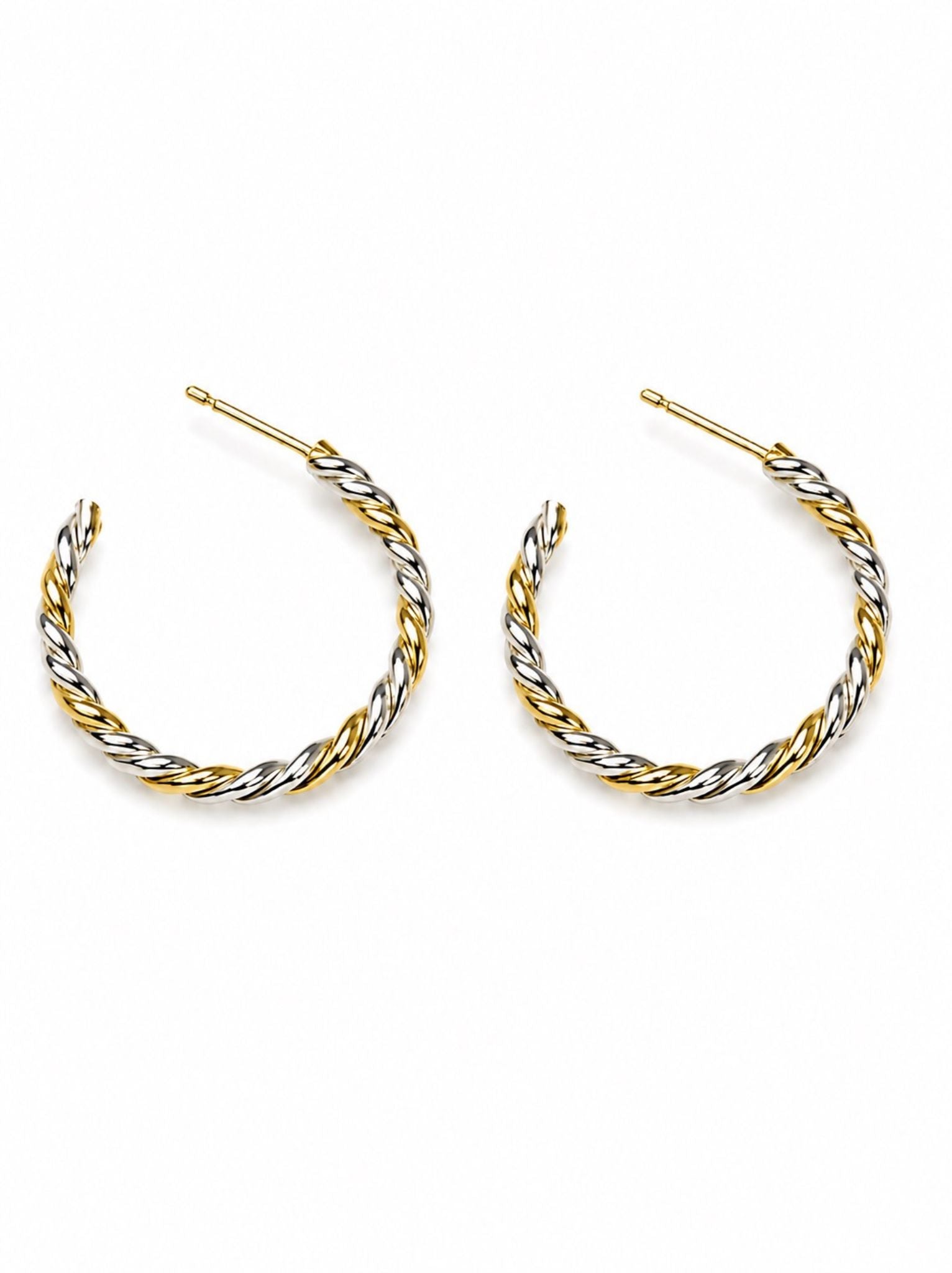 Pair of gold and silver twisted hoop earrings on a white background.
