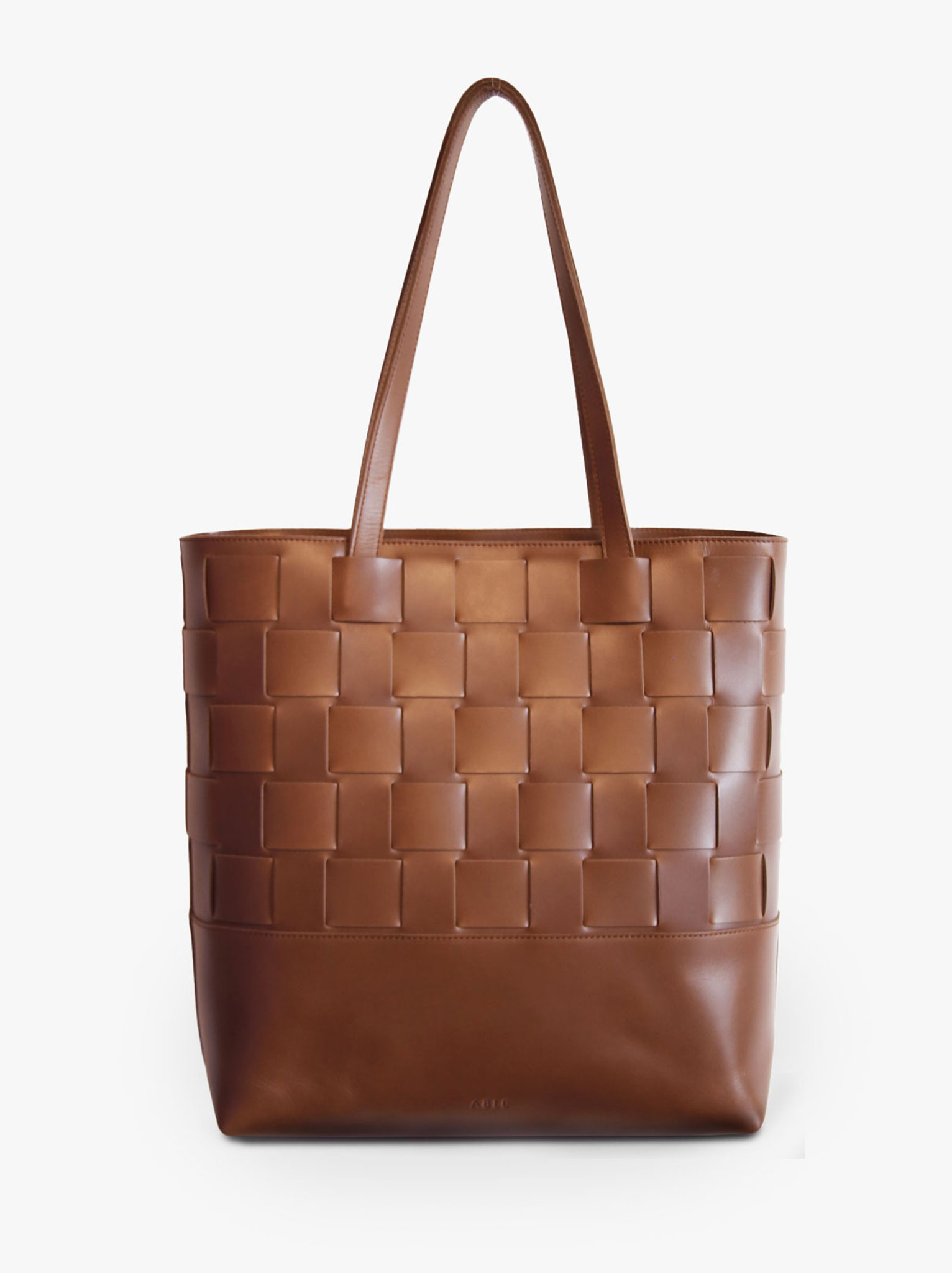 Back of brown leather woven tote with double straps and small brand logo at the bottom. #Color_Whiskey