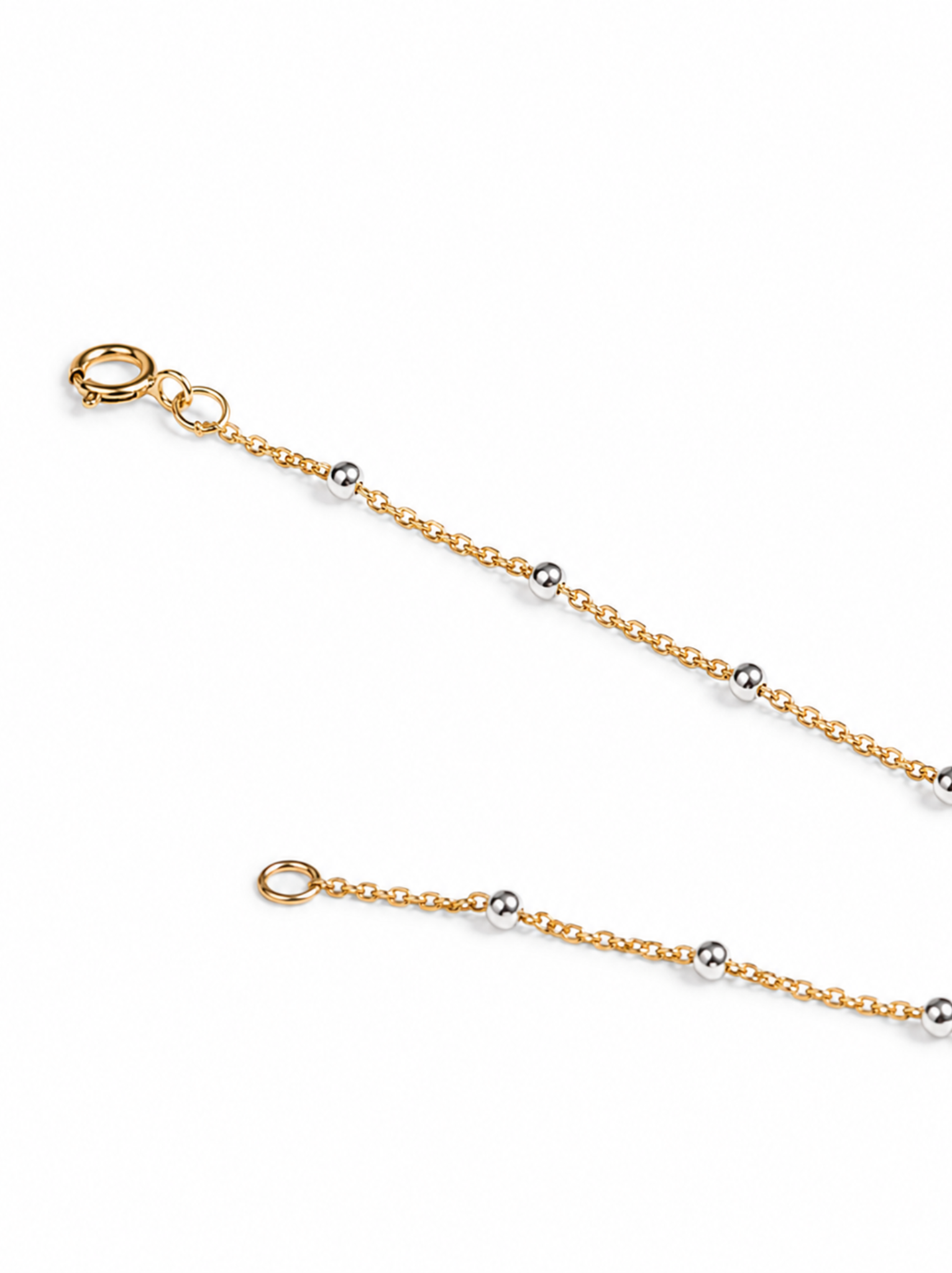 Close up of clasp, gold chain, and silver beads on a white background.